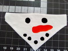 a white bandana with black dots and a red nose