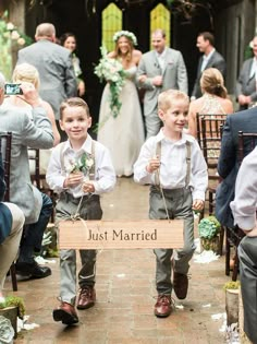 two young boys are walking down the aisle