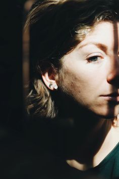 a close up of a person wearing earring's and looking off into the distance