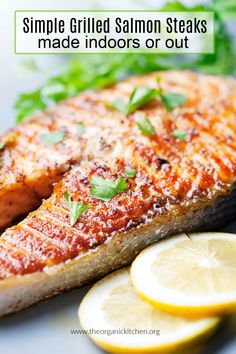 a close up of a fish on a plate with lemons and cilantro