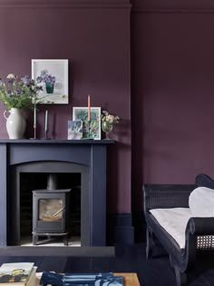 a living room filled with furniture and a fire place in front of a purple wall