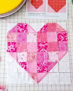 a heart shaped patchwork piece sitting on top of a cutting board