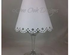 a white lamp shade with black dots on the bottom, and a light bulb attached to it