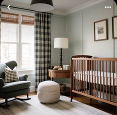 a baby's room with a rocking chair, crib and window in the background