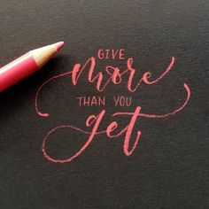 a pink pen sitting on top of a piece of paper that says give more than you get