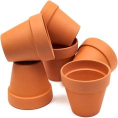 four clay cups stacked on top of each other with one cup in the middle and two empty