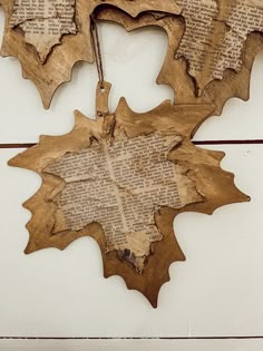 three leaf shaped wooden ornaments hanging on a wall