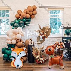 an assortment of balloons and decorations for a baby's first birthday party with animals