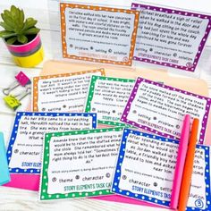 four colorful notebooks sitting on top of a table next to a potted plant