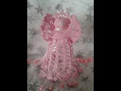 a pink crocheted dress and hat on a white sheet with stars in the background