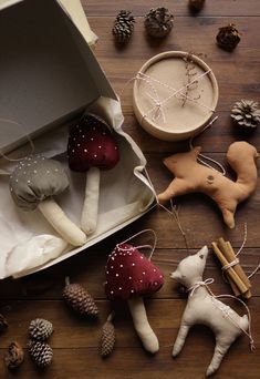 some ornaments are laying out on the floor next to a box with pine cones and other decorations