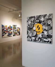 three paintings hang on the wall next to each other in an empty room with white walls