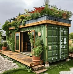 a green shipping container with plants growing on top and stairs leading up to the roof