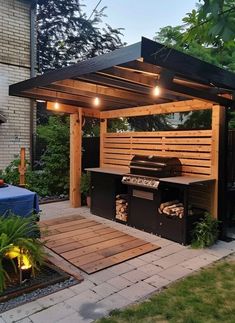 an outdoor bbq with lights on the roof and grilling area in the back yard