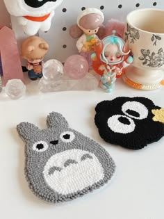 two crocheted animal coasters sitting on top of a table next to toys