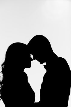 two people standing next to each other in silhouette