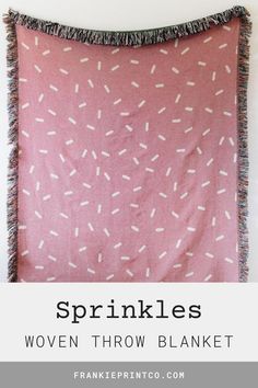 a pink blanket with white sprinkles on it and the words, sprinkles woven throw blanket