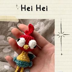 a hand holding a tiny crocheted doll in it's left hand with the words hei hei written above it