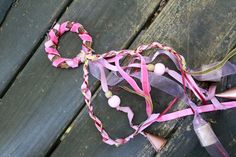 a pair of scissors and some ribbons on a wooden surface with wood planks in the background