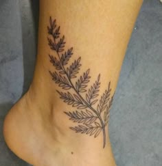 a black and white photo of a foot with a plant tattoo on it's side