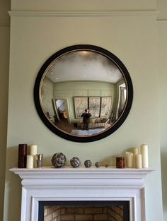 a fire place with a mirror above it