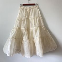 Ivory color 4-tier petticoat with one button and two snaps. Unsure of age. Has a couple small spots but no tears 26" waist 35-1/2" length Cream Tiered Gathered Skirt, Fitted Cream Petticoat With Ruffles, Spring Cream Petticoat With Ruffles, Vintage Tiered Skirt In Cream, Vintage Cream Tiered Skirt, Spring Wedding Cream Petticoat, Fitted Tiered Petticoat, Vintage Tiered Skirt Petticoat For Spring, Vintage White Tiered Skirt