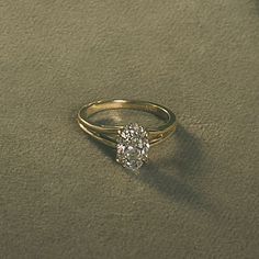 a gold ring with a single diamond on the top and bottom, sitting on sand