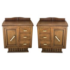 a pair of wooden nightstands with drawers on each side and one drawer open in the middle