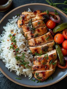 a plate with chicken, rice and vegetables on it