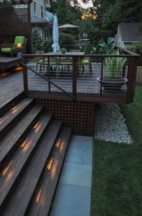 an outdoor deck with steps and lights on it