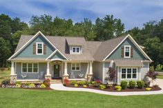 a blue house with lots of windows in the front yard and landscaping on the side