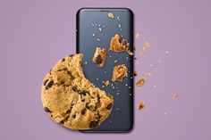 an iphone with a cookie on the screen and half eaten cookies in front of it