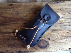 a black leather case sitting on top of a wooden table