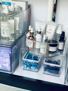 a clear shelf filled with lots of different types of skin care products on top of a counter