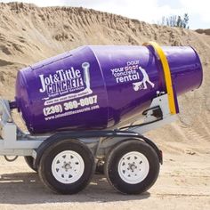 a purple and yellow cement mixer sitting on top of a trailer