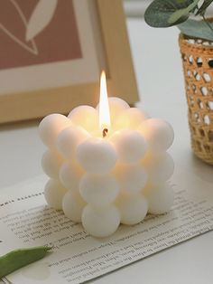 a white candle sitting on top of an open book