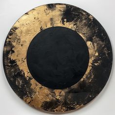 a black and gold plate sitting on top of a white wall