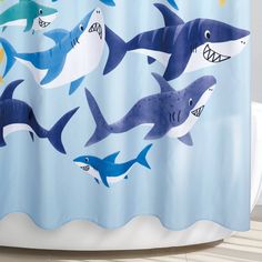 a blue shower curtain with sharks on it