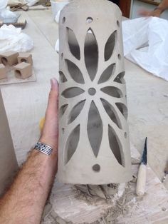 a person is making a vase out of clay