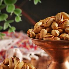 some nuts are in a metal bowl on a table