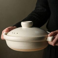 a person holding a white bowl in their hands