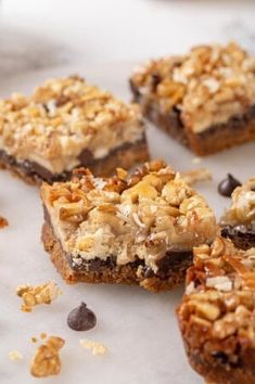 several pieces of dessert sitting on top of a white countertop next to chocolate chips