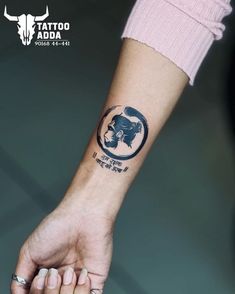 a woman's arm with a tattoo on it that has an animal in the center