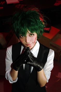 a man with green hair and black gloves