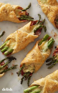 asparagus, bacon and cheese pastries on a marble platter with sprigs