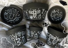 six black and white pots with designs on them sitting on a bed next to each other