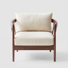 a wooden chair with a white pillow on it's back and armrests