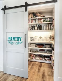 an open pantry with sliding doors and lots of food on the shelves in front of it