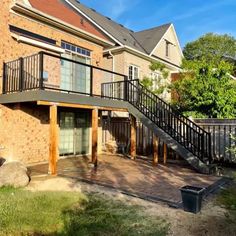 a brick building with stairs leading up to the second floor and an open patio area