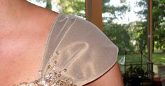 the back of a woman's dress with gold sequins and beads on it